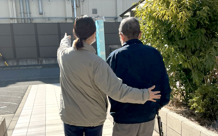 スタッフが入居者に寄り添って歩く様子